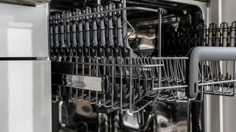 An open dishwasher loaded in a kitchen