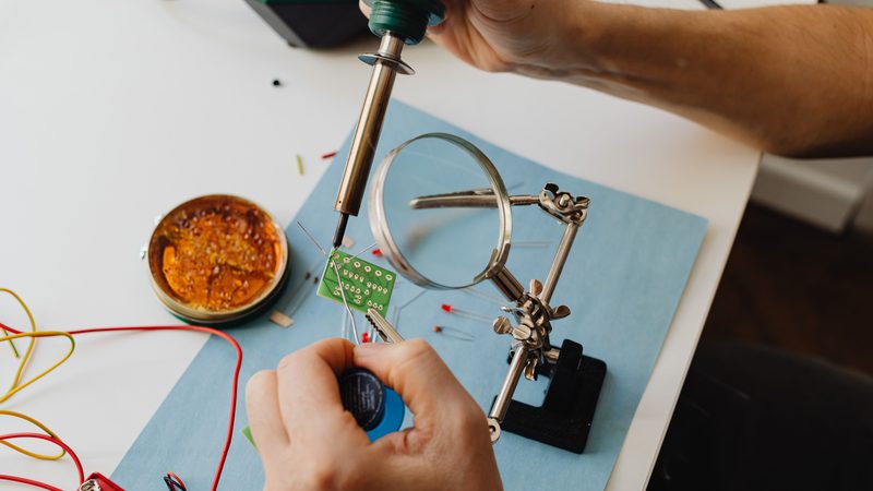A technician soldering components on a circuit board