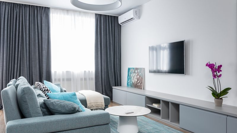 A living room with a wall-mounted air conditioning unit